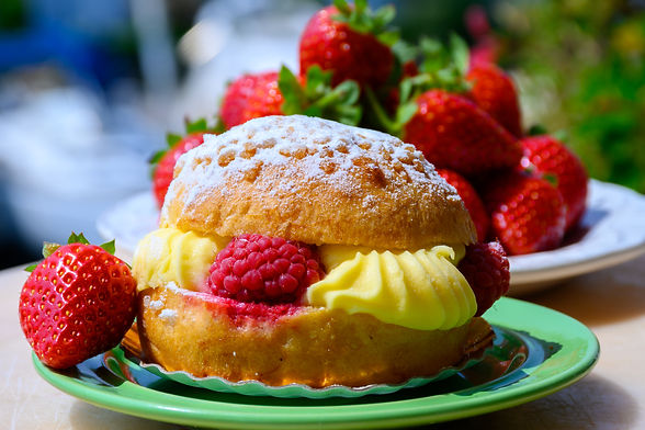 a slice of raspberry tarte tropézienne on a plate served on the occasion of a dessert