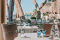 a server installing clients at the table of a luxury restaurant in Saint-Tropez