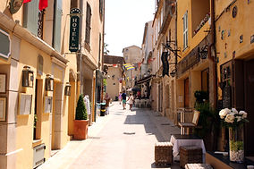 Tourists walking through a narrow street in the La Ponche district of Saint-Tropez on the