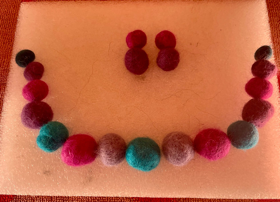 Thumbnail: the woollen beads set out to look like a necklace and a pair of earrings on a white background