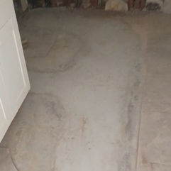 Concrete subfloor and exposed wall framing in a gallery renovation.