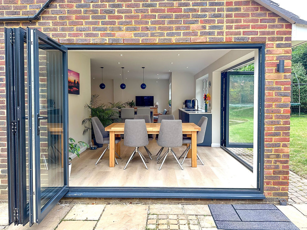 Bifold doors opening to the garden from a modern shaker kitchen with an island