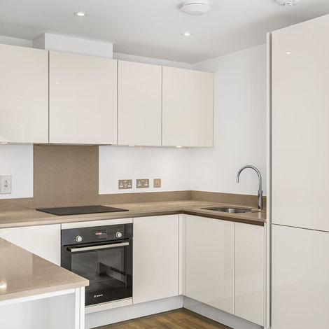 Modern white kitchen with built-in oven and U-shaped layout in a Reading new-build