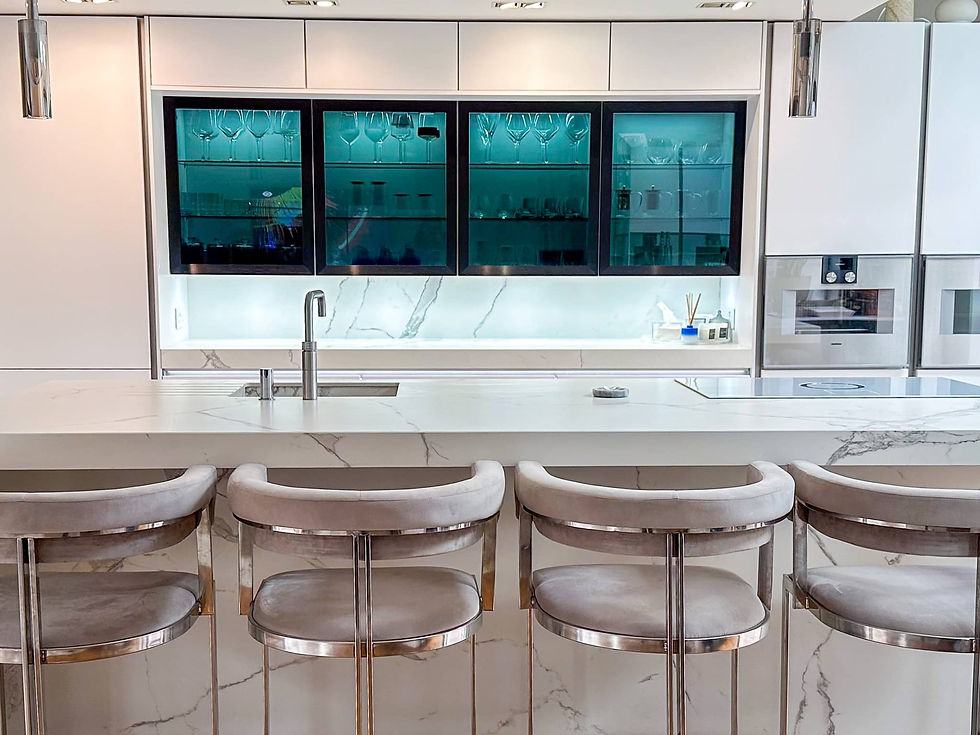 Contemporary kitchen with a glass-fronted cabinet, white marble worktops and soft lighting