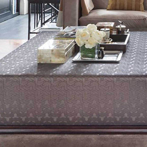 The Langham Ottoman is a sophisticated centerpiece featuring a low-profile silhouette upholstered in a high- quality, geometr