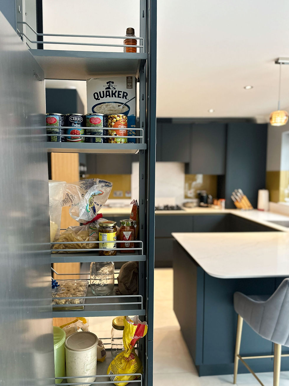 Pull-out pantry storage in a modern kitchen with a quartz worktop