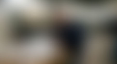 En operatör utför noggranna mätningar av en metallkomponent ute i verkstaden.