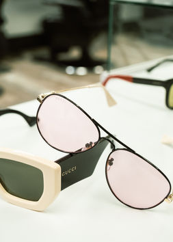 Gucci sunglasses sitting on a white table top at the Vibes & Visions salon.