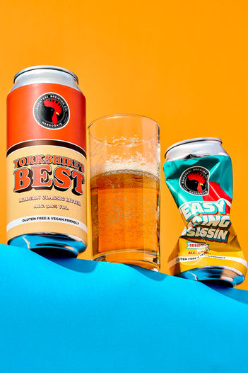 still life drink photo of Yorkshire best beer can set on a blue and orange backdrop 
