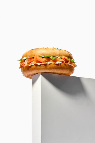 Styled food photography of salmon and cheese bagel with props on white backdrop, Yorkshire 