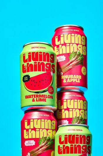 creative commercial product photography of stacked green and red living things soda can set on a bold  blue backdrop, North Yorkshire 