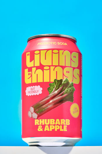 commercial product photo of red living things  soda can set on a blue backdrop, product photography, North Yorkshire 