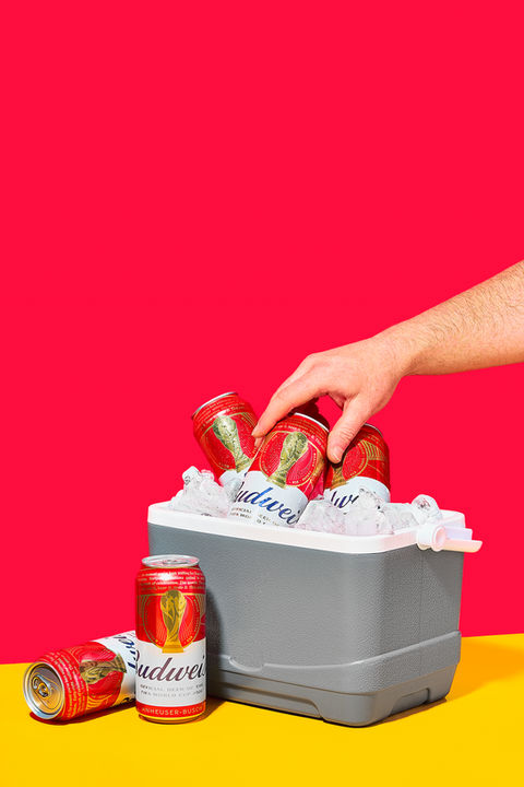Budweiser world football cup cans stuck in ice cooler set on bold split backdrop, with hand pulling can out of cooler, drink photography, London