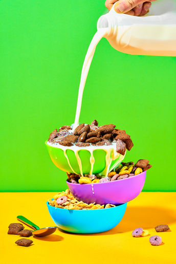 Chocolate cereal poured into a colourful bowl with milk splash on a bold green and yellow background — FMCG food and drink photography UK