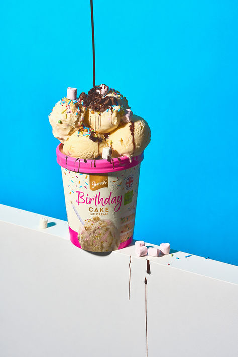 conceptual food photography of giannis birthday cake ice cream set on bold colourful blue and white backdrop, with chocolate sauce pouring on top of the ice cream, food photography Yorkshire