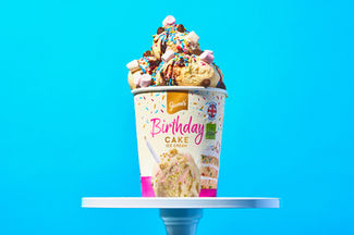 food photography of giannis birthday cake ice cream on cake stand, set on a bold blue backdrop , North Yorkshire 