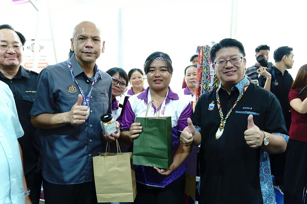 Ewon dan Armizan bergambar bersama salah seorang pempamer semasa lawatan ke tapak pameran
