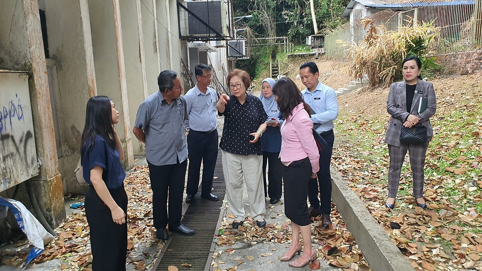 Liew (left), accompanied by government officials, pointing to the extensive debris at the fire site.