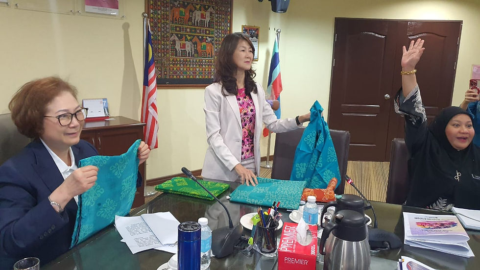 Liew (left) and Lai choosing the batik material with the Murut ethnic motif for the official attire to be worn during the Malaysia Day Celebration.
