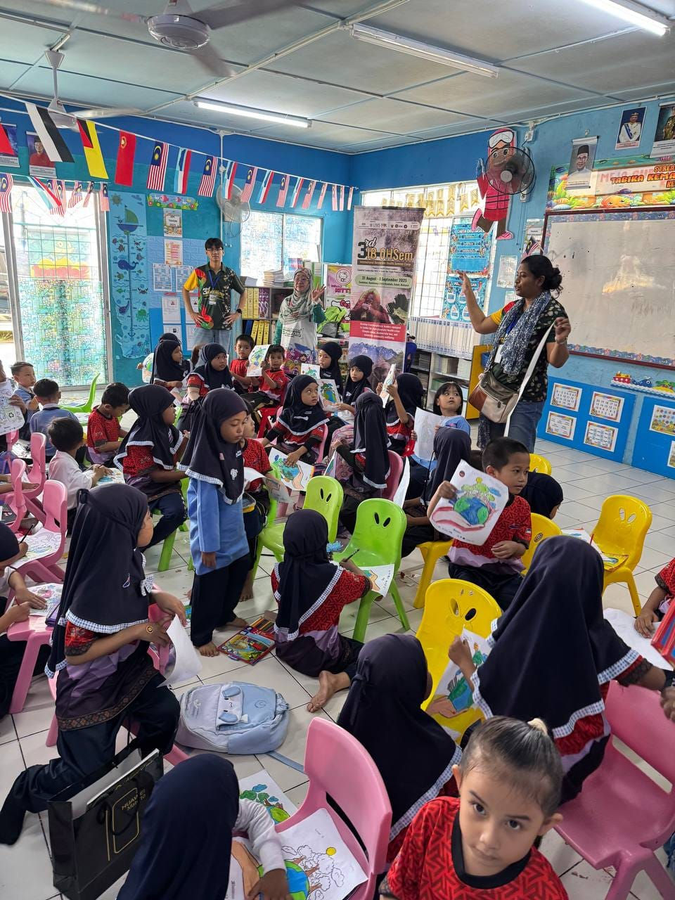Dr. Tanjela Bushra, Penyelidik dari Bangladesh Medical University sedang memberikan penerangan tentang aktiviti mewarna berkenanan perubahan iklim kepada murid Tadika Kemas Kampung Tunisa 2, Sandakan.