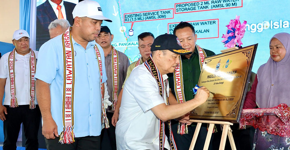 Hajiji menandatangani plak pada Majlis Pecah Tanah Projek Skim Penambahan Bekalan Air Pulau Banggi di Dewan Terbuka Kobong, Pulau Banggi pada Sabtu.