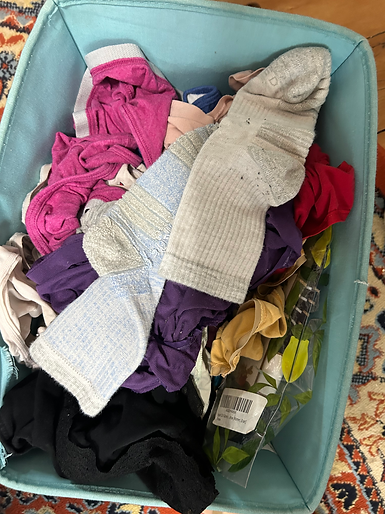 unfolded socks and underwear are piled into a little basket that fits neatly under the bed
