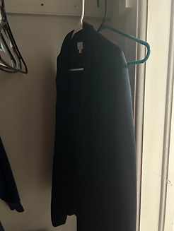 One black blazer hangs in a little closet