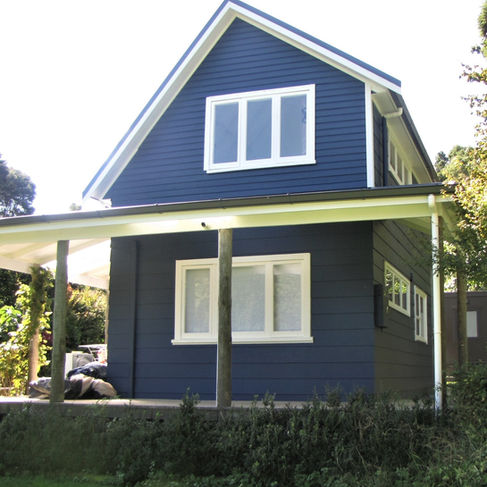 After picture of house beautifully painted in blue with white trim