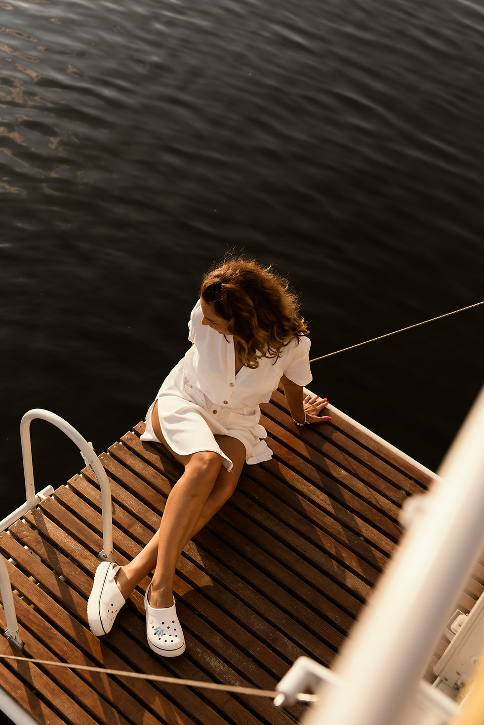 Woman on a boat enjoying the serene ocean, showcasing PLACE’s luxurious yacht charter services.