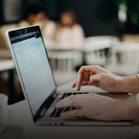 An image of a hand typing on a laptop