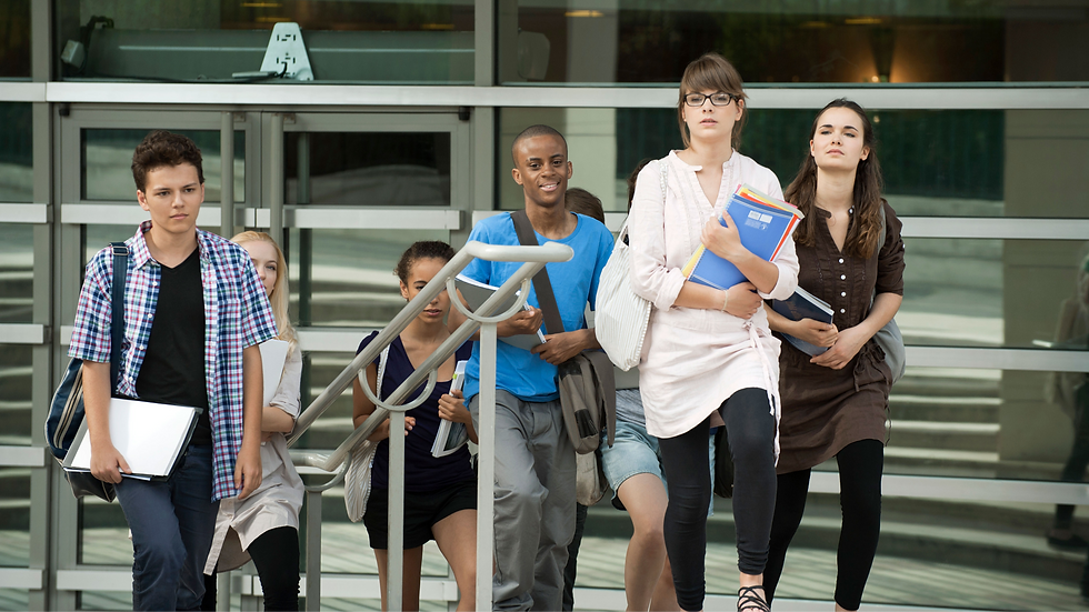 Un groupe d'étudiants descend des escaliers devant un bâtiment moderne en verre, portant des livres et sacs, souriants et concentrés.