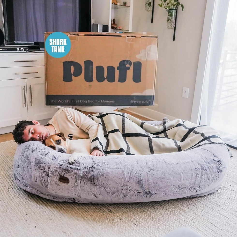 Young man and dog snuggled in a large dog bed