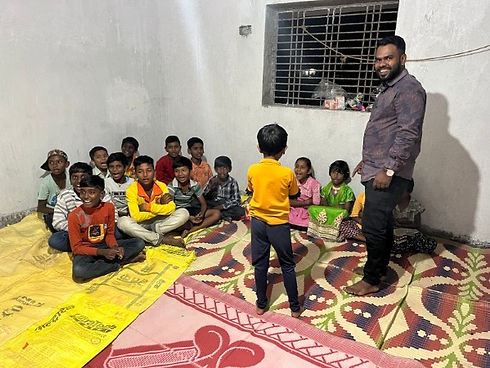 Indian man standing with several Indian children in a ministry