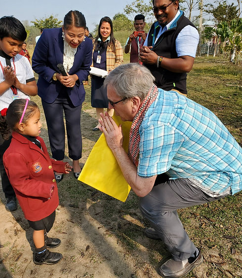 American man kneeling and praying next to young Indian school girl