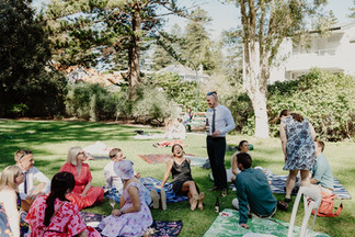 The groom laughing with guests at the picnic in Sunken Garden at Cottesloe Civic Centre