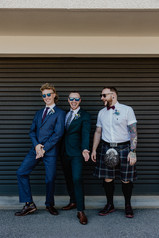The groomsmen laughing together standing in front of a garage door