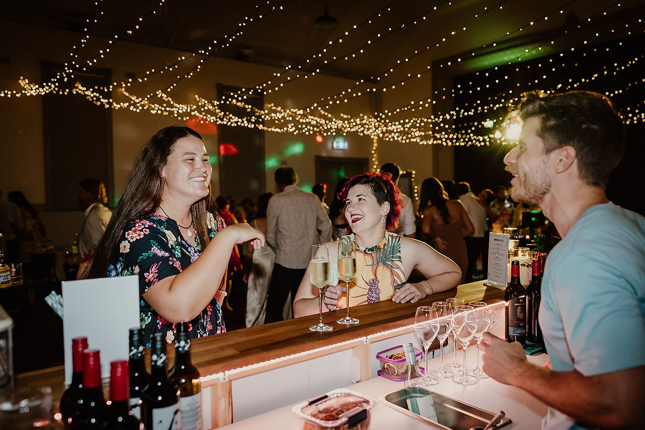 Guests laughing at the bar with Josh from The Bar Boy