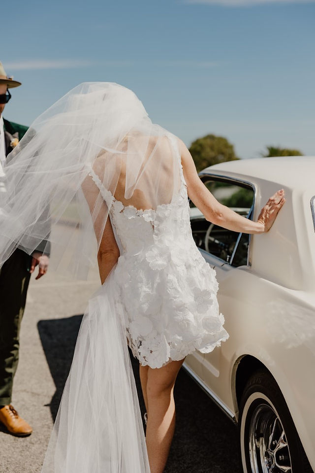 A white mini dress with oversized veil