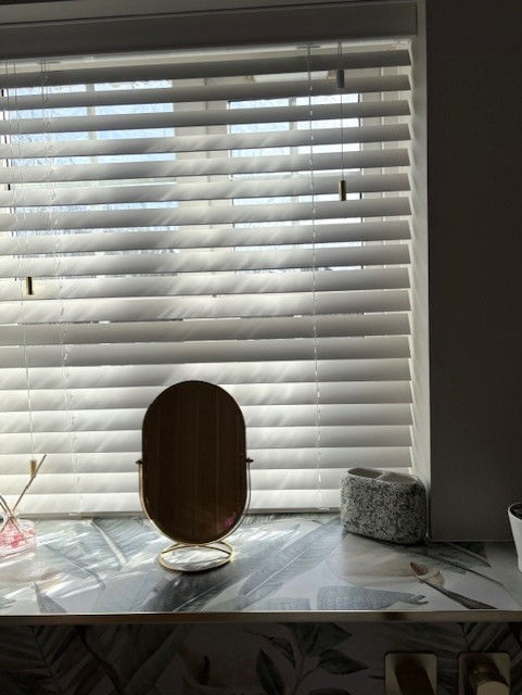 Window with blinds and small decorative vase on sill