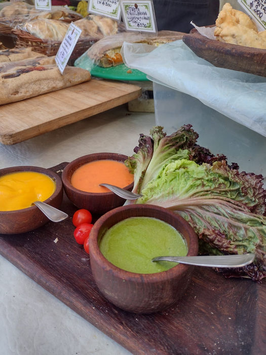 Bowl de barro con sopa verde y hojas verdes decorando el plato