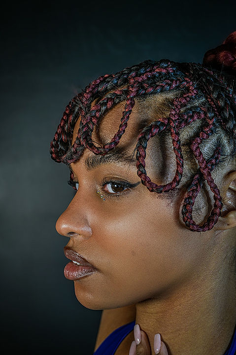 Skilled African hair braider creating intricate styles in Toronto.