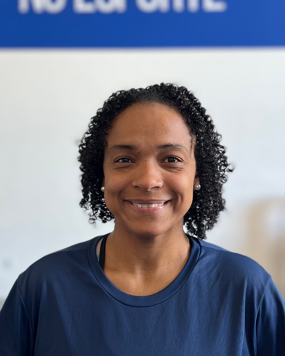 Instrutora de ginástica artística e circo no Butantã sorrindo no ginásio Ouro no Esporte.