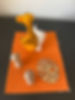 une marionnette à doigt girafe, 2 figurines en bois, une forme évidée en bois, le tout posé sur un rectangle de feutrine orange, jpg