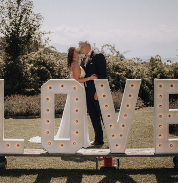 Hochzeitsgäste mit Accessoires machen Fotos mit einer Fotobox auf einer Hochzeit