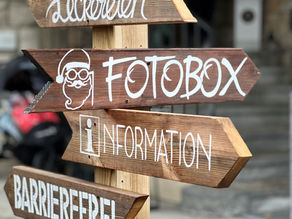 Holzschild mit Fotobox Beschriftung in Baden vor einer Fotobox von SnapBox - Fotobox Vermietung an einem Kundenevent