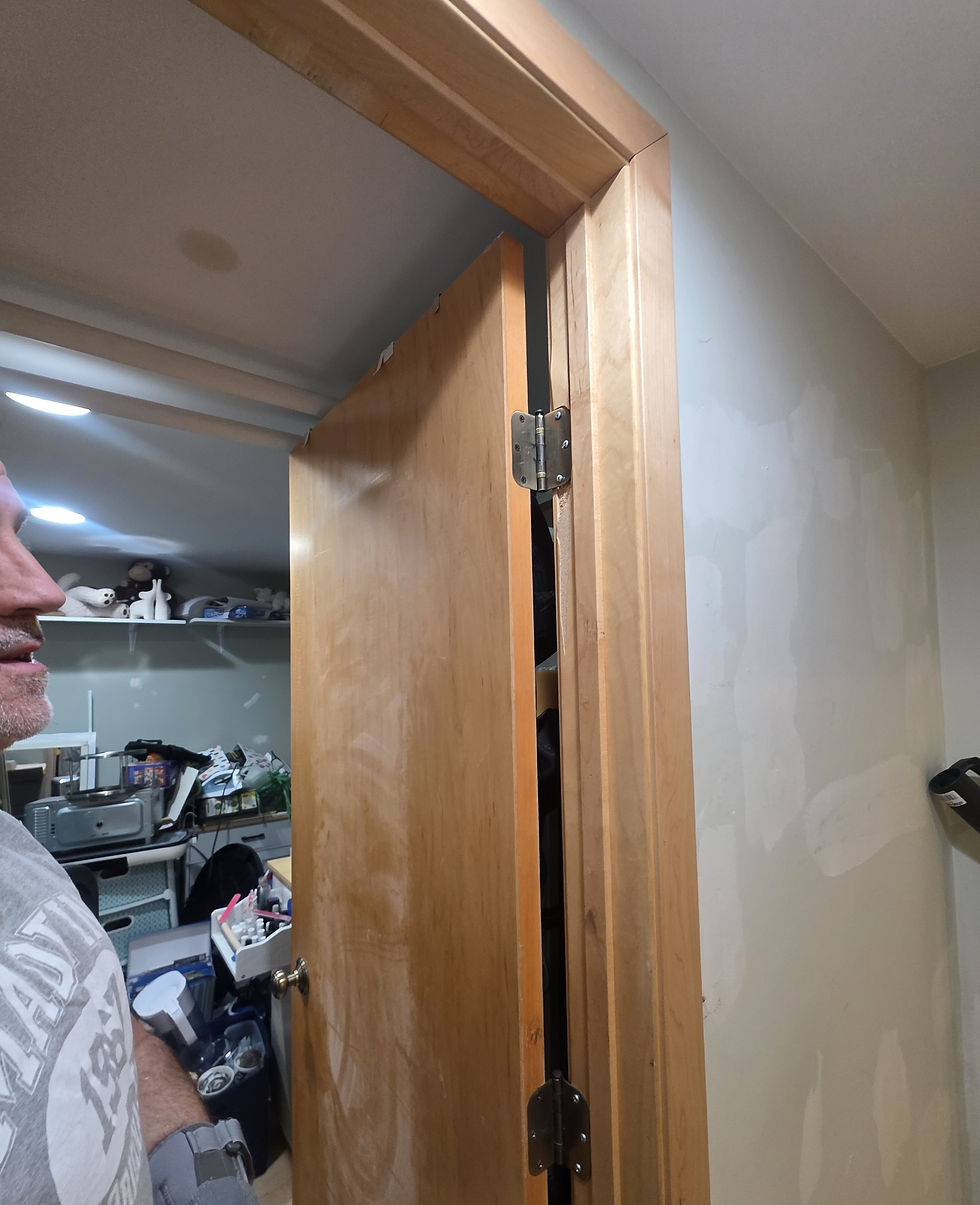 Basement storage door hanging off-center, with the hinge screws that needed replacing