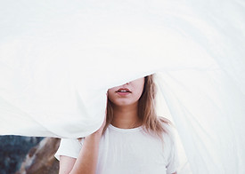 Fille derrière une feuille