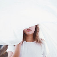 Fille derrière une feuille