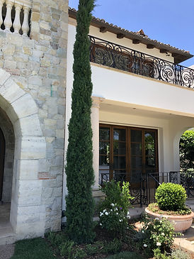 Commercial landscape design with tall evergreens and stonework entry in Fillmore, California
