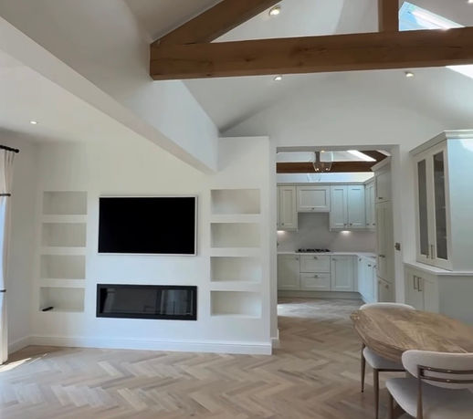Bespoke kitchen designed as part of a garage conversion, with classic cabinetry, herringbone flooring and exposed timber ceiling beams.